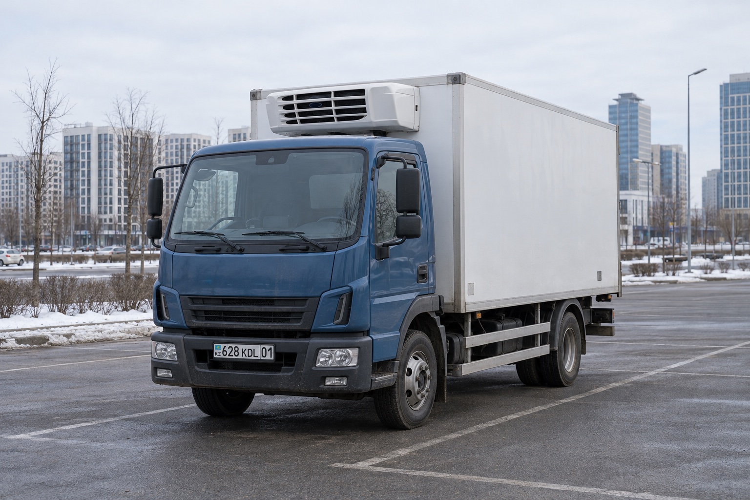 Illustration d’un camion frigorifique à cabine bleue sur un parking urbain en hiver à Astana