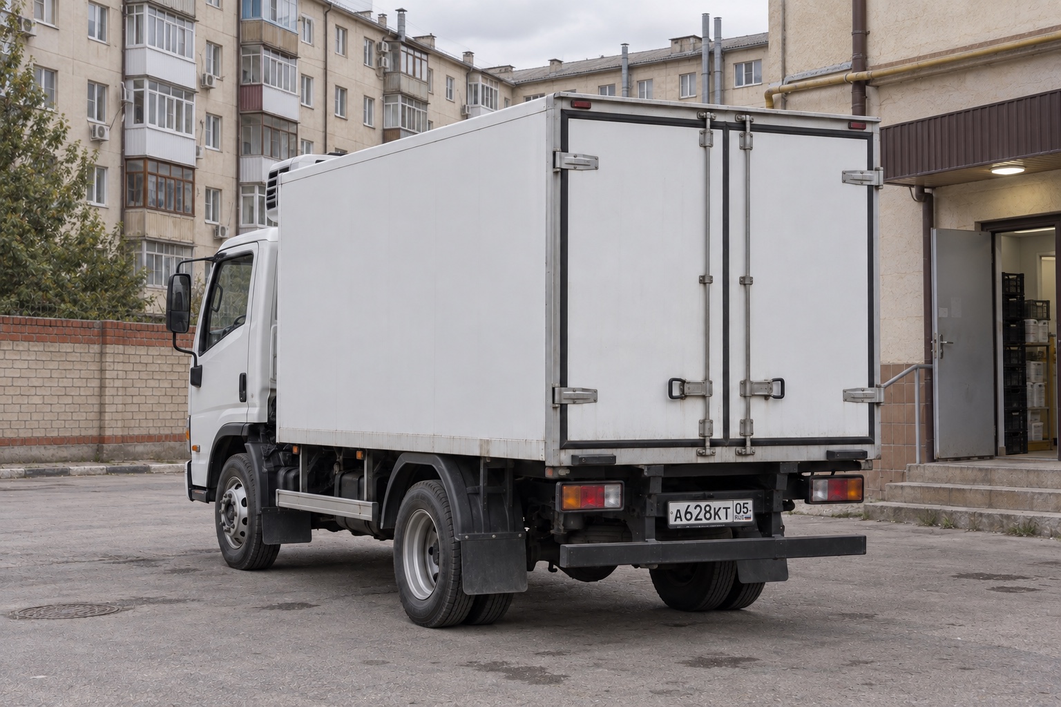 Illustration d’un camion frigorifique de livraison de produits laitiers près d’un commerce de quartier au Daghestan, en Russie