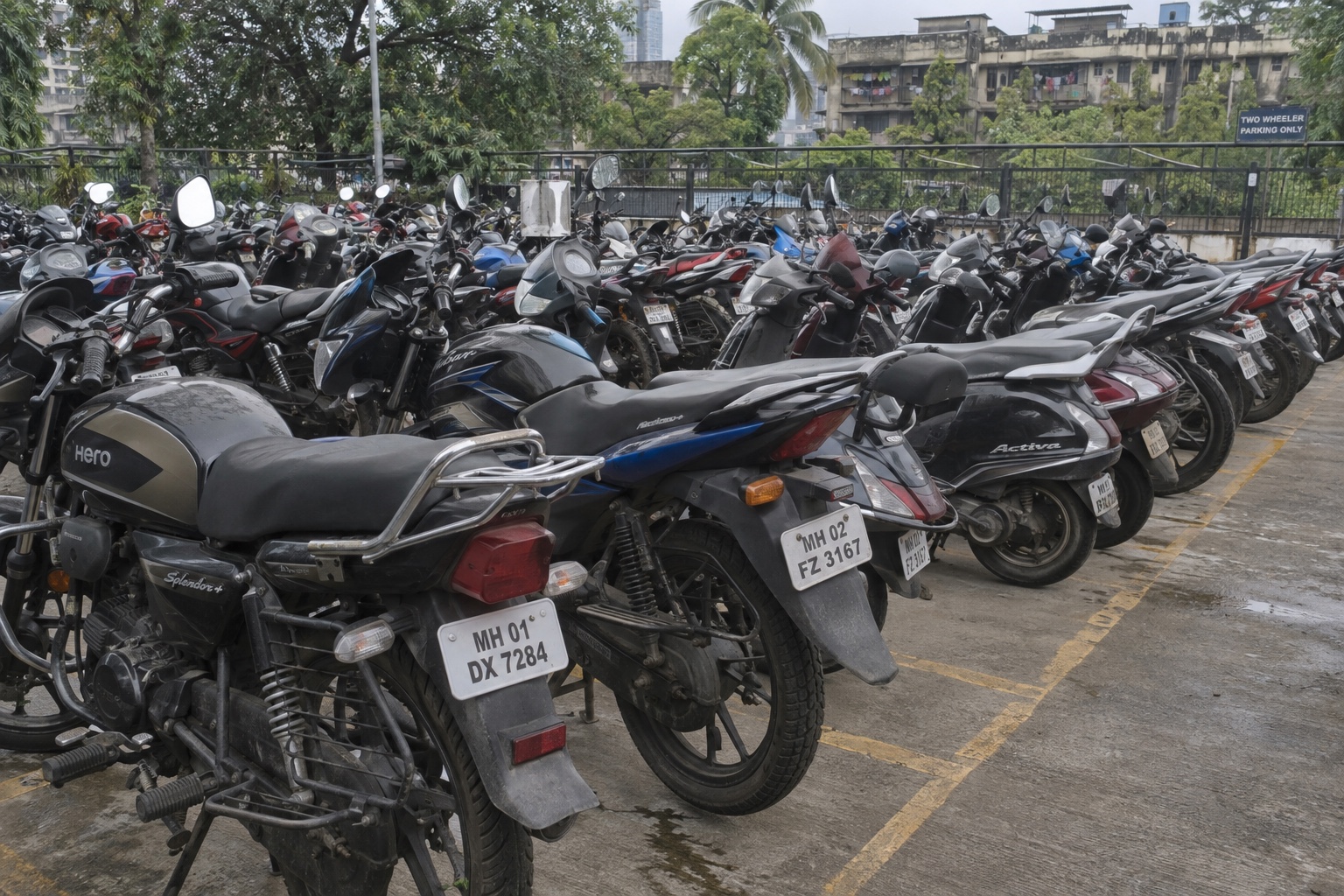 Motos de diversos modelos estacionadas juntas en una zona dedicada fuera de la calle en Mumbai — escena ilustrativa