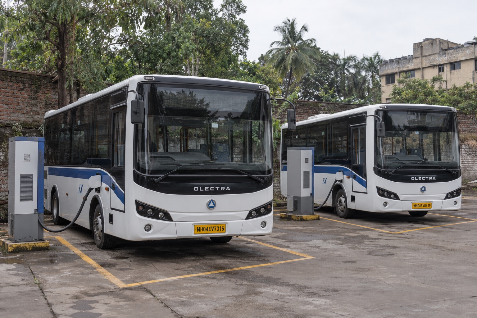 Imagen ilustrativa de autobuses eléctricos de personal conectados a dos estaciones de carga en un depósito de Mumbai