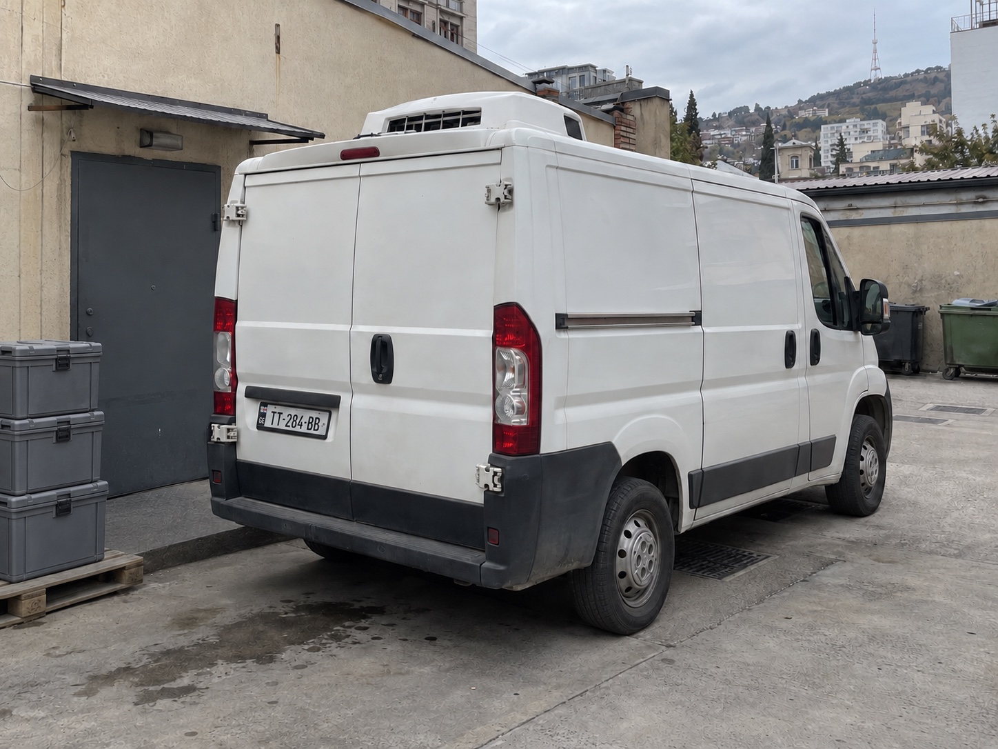Camioneta refrigerada en un patio de servicio fuera de la calle en Tbilisi, Georgia; escena ilustrativa