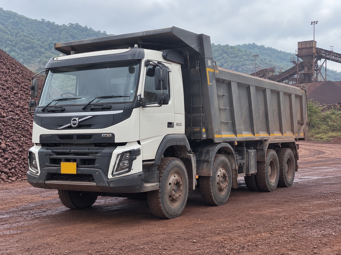 A Volvo FMX mining tipper with its body lowered at an ore stockyard in India — illustrative scene