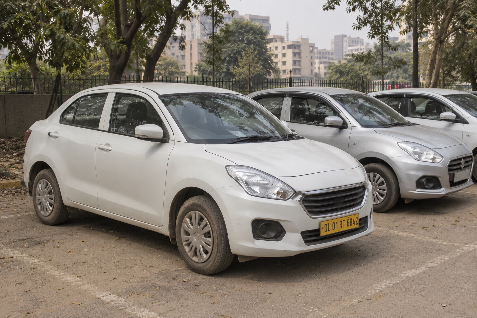 Passenger-transport sedans parked at a designated staging area in Delhi — illustrative scene