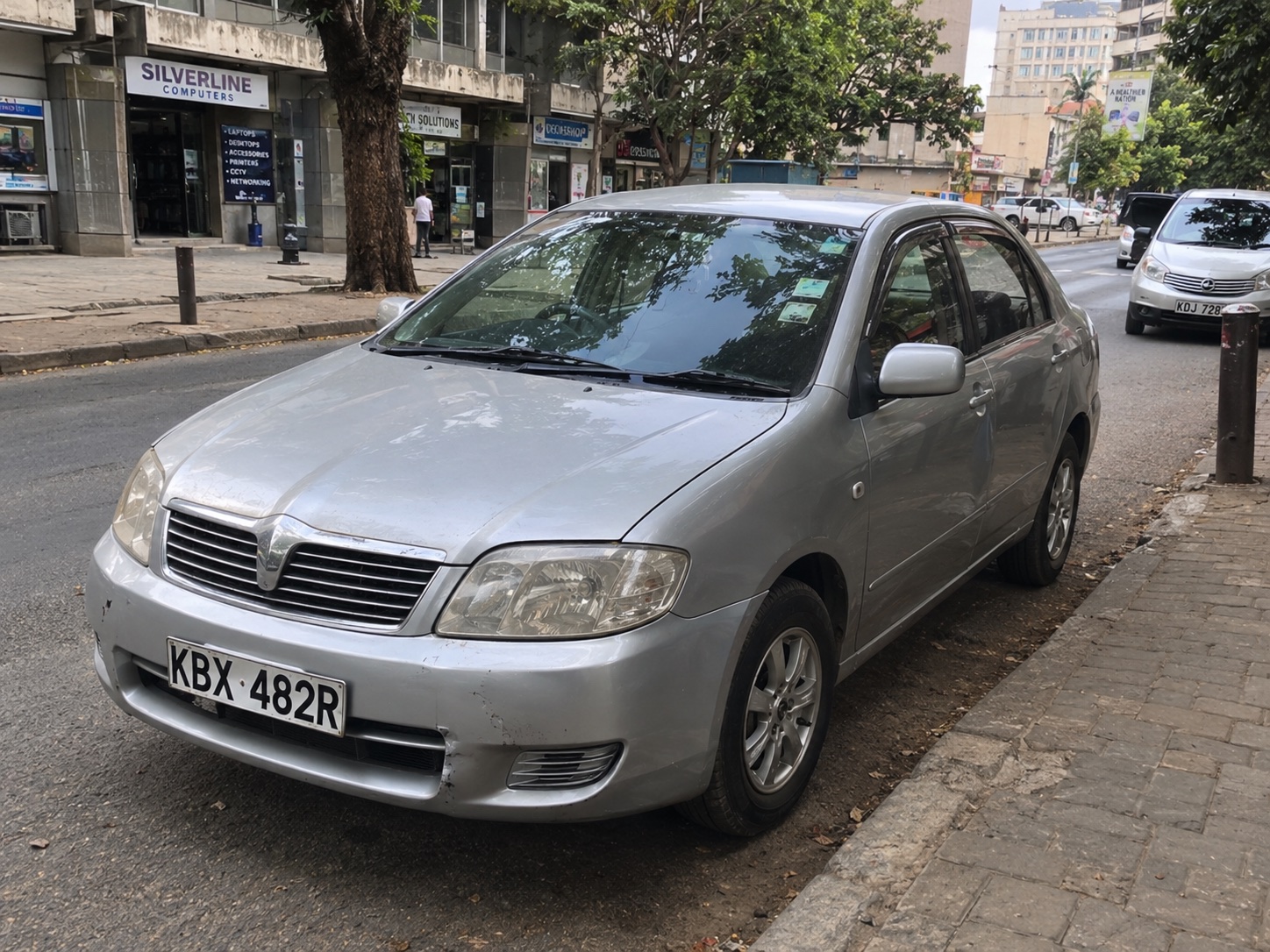 Silver urban taxi car parked on an everyday Nairobi street in Kenya